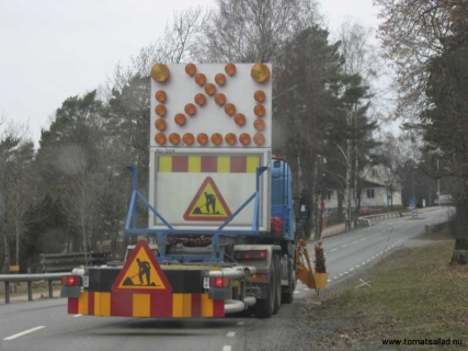 Bil som plockar upp de orange snöröjningspinnarna